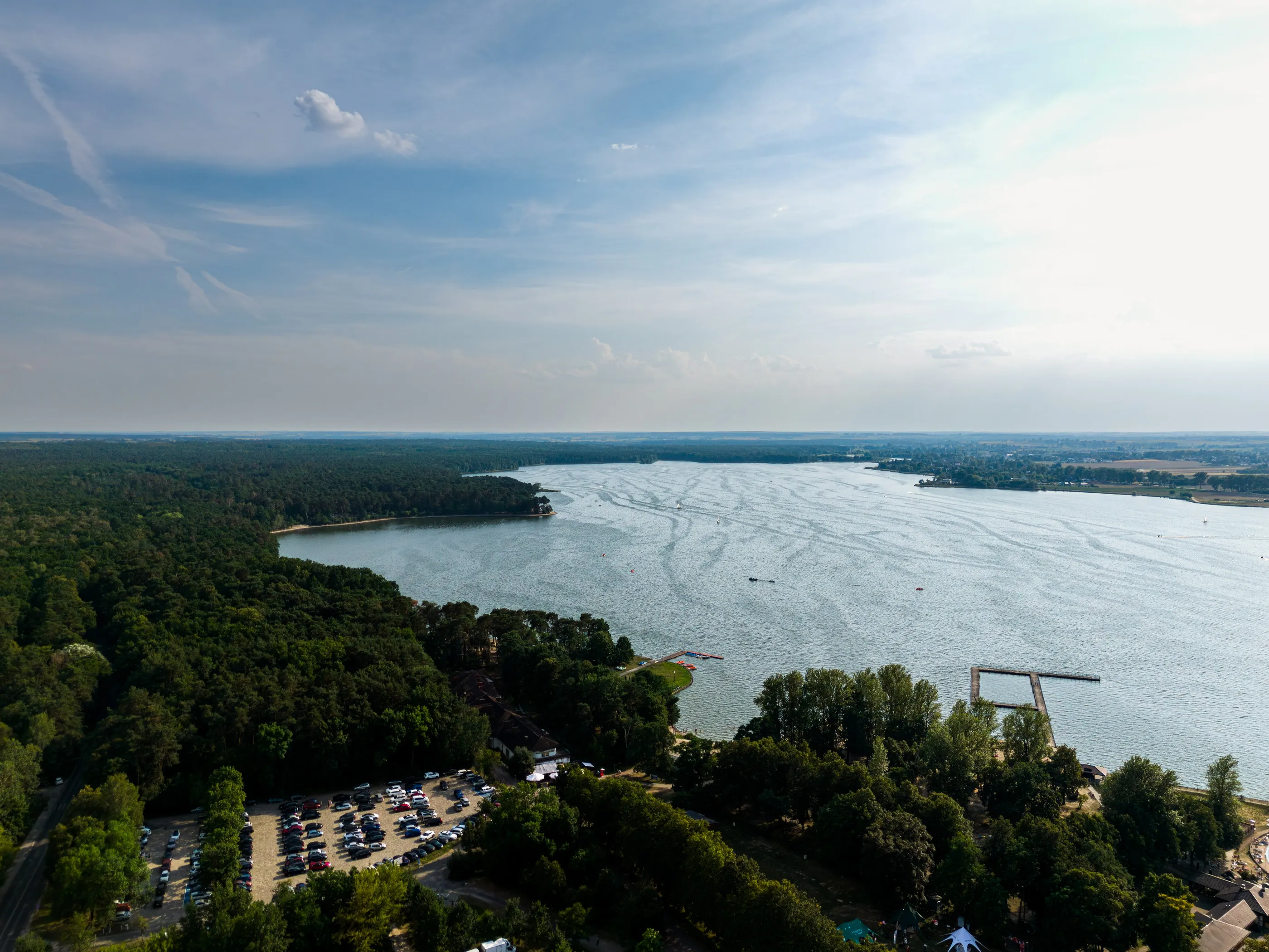 Jezioro otoczone lasem w dzień, widok z drona